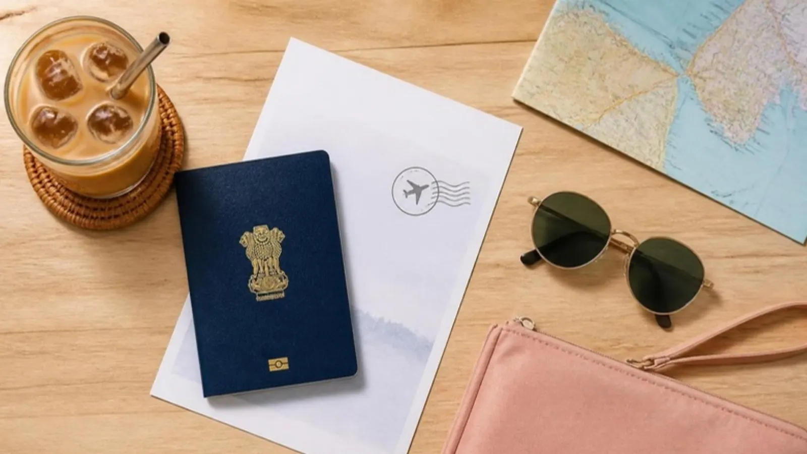 Indian passport and Vietnam e-visa printout on a table with a coffee and map of Vietnam